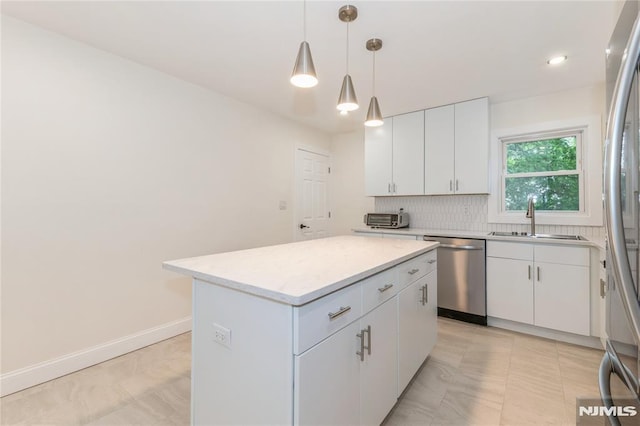 63 E Midland Ave, Kearny, NJ 07032 - kitchen with appliances with stainless steel finishes, a center island, decorative backsplash, white cabinetry, and pendant lighting