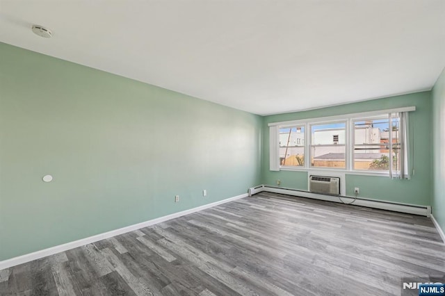 17 Cuozzo St Unit 27, Belleville, NJ 07109 - spare room with wood finished floors, a wall mounted air conditioner, baseboard heating, and a smoke detector