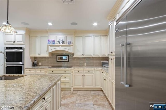 4 Lowell Ct Unit 704, Teaneck, NJ 07666 - kitchen with appliances with stainless steel finishes, cream cabinetry, decorative light fixtures, light stone counters, and recessed lighting