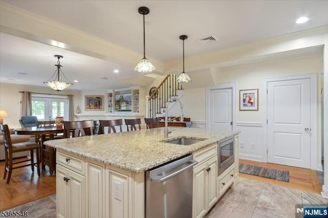 4 Lowell Ct Unit 704, Teaneck, NJ 07666 - kitchen with appliances with stainless steel finishes, cream cabinetry, light stone countertops, hanging light fixtures, and recessed lighting