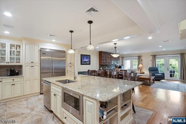 4 Lowell Ct Unit 704, Teaneck, NJ 07666 - kitchen featuring built in appliances, cream cabinets, backsplash, a kitchen island with sink, and recessed lighting