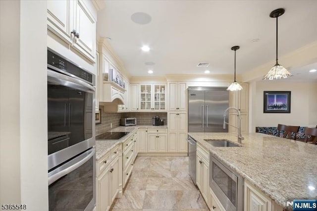 4 Lowell Ct Unit 704, Teaneck, NJ 07666 - kitchen with built in appliances, decorative backsplash, light stone countertops, crown molding, and hanging light fixtures