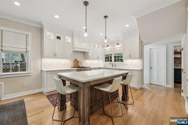 490 Ackerman Ave, Ho-Ho-Kus, NJ 07423 - kitchen with premium range hood, light countertops, a kitchen bar, white cabinets, and recessed lighting