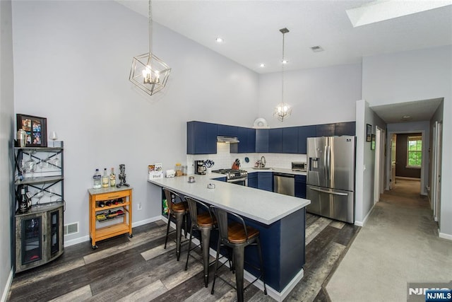 462 Poets Way, Mahwah, NJ 07430 - kitchen featuring appliances with stainless steel finishes, a peninsula, a chandelier, high vaulted ceiling, and light countertops