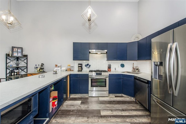 462 Poets Way, Mahwah, NJ 07430 - kitchen with stainless steel appliances, blue cabinets, under cabinet range hood, light countertops, and dark wood-style floors