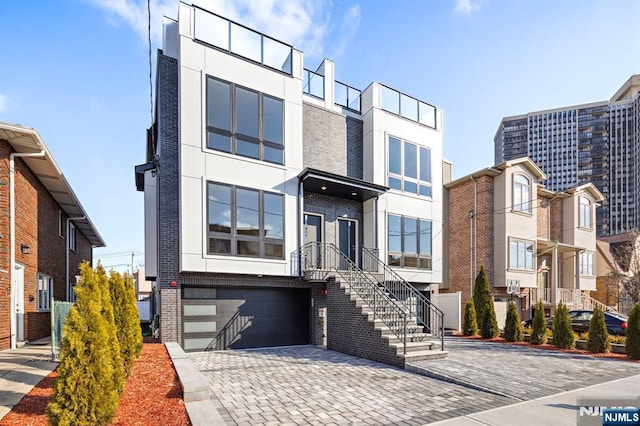 227 Wayne Ave Unit A, Cliffside Park, NJ 07010 - contemporary home featuring a garage, stucco siding, driveway, and brick siding