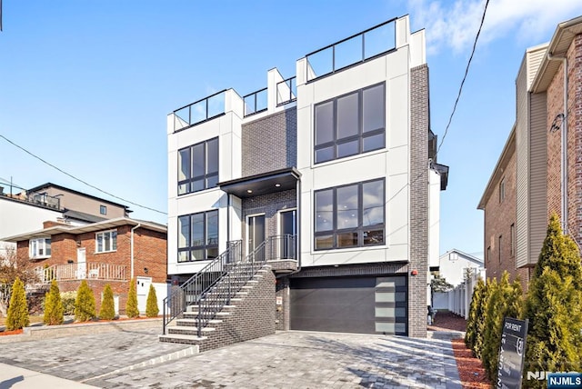 227 Wayne Ave Unit A, Cliffside Park, NJ 07010 - contemporary house featuring brick siding, stucco siding, a garage, and driveway