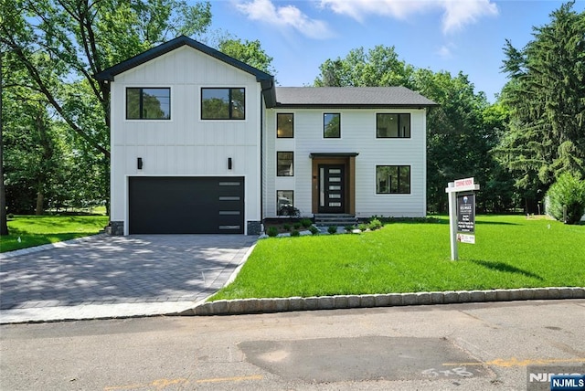 30 Benjamin Rd, Tenafly, NJ 07670 - contemporary home featuring an attached garage, board and batten siding, a front lawn, and decorative driveway