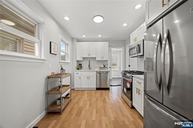 422 Davis Ave, Kearny, NJ 07032 - kitchen featuring appliances with stainless steel finishes, light countertops, light wood-style flooring, white cabinetry, and recessed lighting
