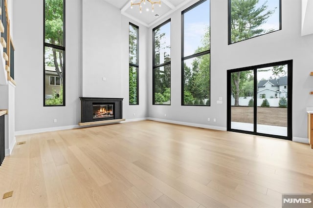172 Birchwood, Old Tappan, NJ 07675 - unfurnished living room featuring a glass covered fireplace, a high ceiling, and light wood-style flooring