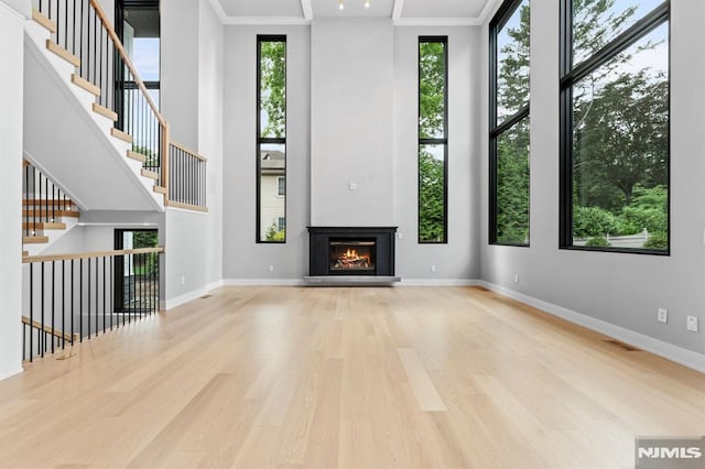 172 Birchwood, Old Tappan, NJ 07675 - unfurnished living room featuring wood finished floors, a glass covered fireplace, and a towering ceiling