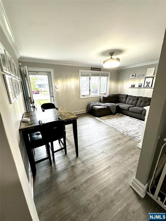 265 Wilson St, Saddle Brook, NJ 07663 - living area with healthy amount of natural light, ornamental molding, a baseboard radiator, and dark wood-style flooring