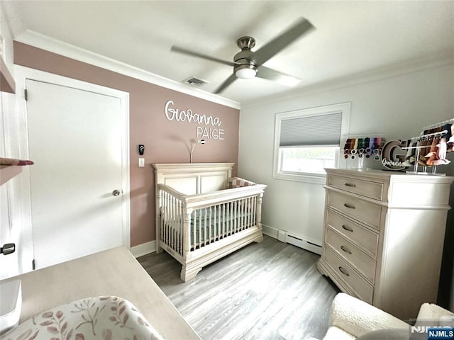 265 Wilson St, Saddle Brook, NJ 07663 - bedroom featuring crown molding, a baseboard radiator, a nursery area, light wood-type flooring, and a ceiling fan