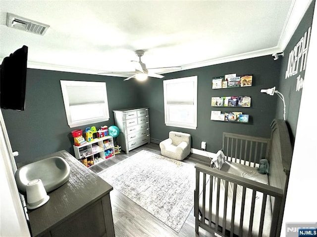 265 Wilson St, Saddle Brook, NJ 07663 - bedroom with ornamental molding, a crib, wood finished floors, and ceiling fan