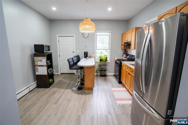 95 Mount Prospect Ave, Newark, NJ 07104 - kitchen with appliances with stainless steel finishes, a baseboard radiator, light wood finished floors, light countertops, and a breakfast bar area