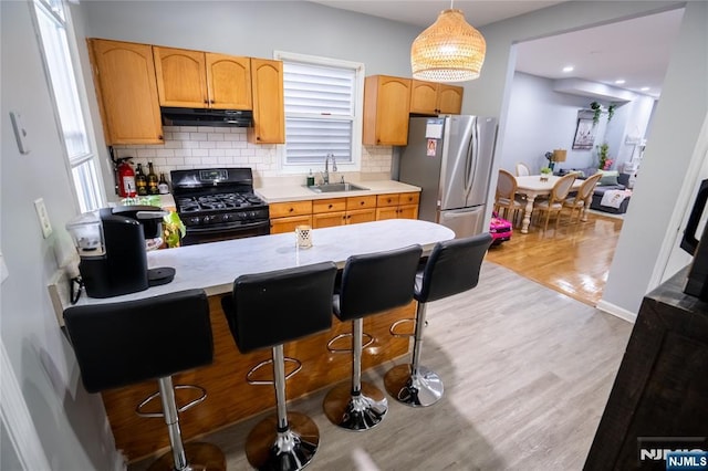 95 Mount Prospect Ave, Newark, NJ 07104 - kitchen featuring gas stove, under cabinet range hood, freestanding refrigerator, and light countertops
