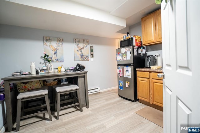 95 Mount Prospect Ave, Newark, NJ 07104 - kitchen featuring freestanding refrigerator, a baseboard heating unit, light wood finished floors, black microwave, and light countertops