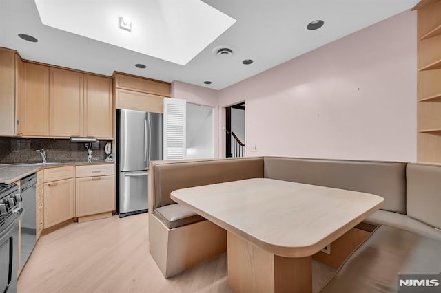 0-04 Pine Ave, Fair Lawn, NJ 07410 - kitchen with freestanding refrigerator, light brown cabinets, backsplash, light wood finished floors, and a skylight