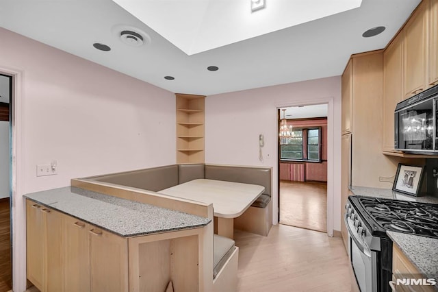 0-04 Pine Ave, Fair Lawn, NJ 07410 - kitchen featuring black microwave, stainless steel range with gas stovetop, light wood finished floors, light brown cabinets, and light stone countertops
