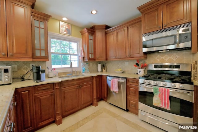 218 Evergreen St, Hillsdale, NJ 07642 - kitchen featuring appliances with stainless steel finishes, brown cabinetry, backsplash, glass insert cabinets, and recessed lighting