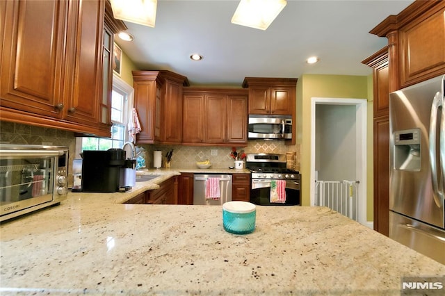 218 Evergreen St, Hillsdale, NJ 07642 - kitchen with appliances with stainless steel finishes, tasteful backsplash, light stone countertops, brown cabinetry, and recessed lighting