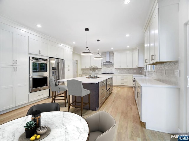 345 Creek Bed Rd, Mountainside, NJ 07092 - kitchen featuring wall chimney exhaust hood, appliances with stainless steel finishes, a breakfast bar, a center island, and white cabinets