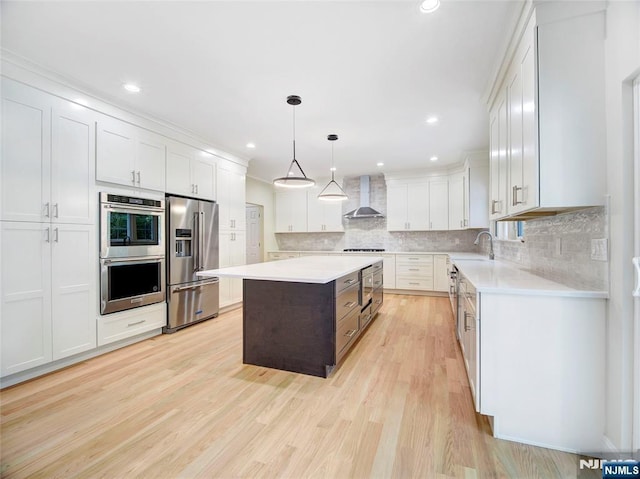 345 Creek Bed Rd, Mountainside, NJ 07092 - kitchen with stainless steel appliances, wall chimney range hood, light countertops, light wood finished floors, and recessed lighting
