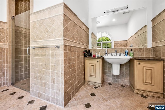 82 Jackson Dr, Cresskill, NJ 07626 - full bathroom featuring tile walls, tile patterned flooring, a shower stall, and a wainscoted wall
