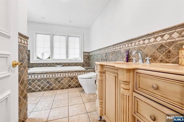 82 Jackson Dr, Cresskill, NJ 07626 - bathroom featuring tile patterned floors, a bath, vanity, wainscoting, and tile walls
