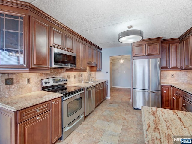 250 Gorge Rd Unit 16D, Cliffside Park, NJ 07010 - kitchen with stainless steel appliances, decorative backsplash, light stone counters, and a textured ceiling