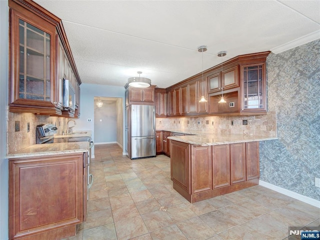 250 Gorge Rd Unit 16D, Cliffside Park, NJ 07010 - kitchen with appliances with stainless steel finishes, a peninsula, light stone counters, brown cabinets, and ornamental molding