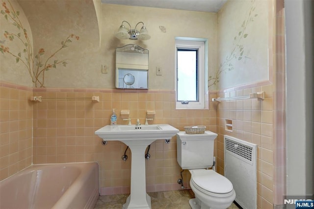 548 Standish Rd, Teaneck, NJ 07666 - full bathroom with radiator heating unit, a bath, tile walls, wainscoting, and tile patterned flooring
