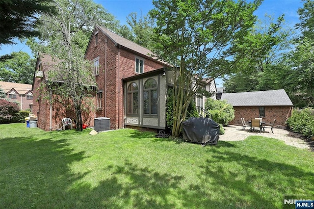 548 Standish Rd, Teaneck, NJ 07666 - back of house featuring a lawn, brick siding, and a patio