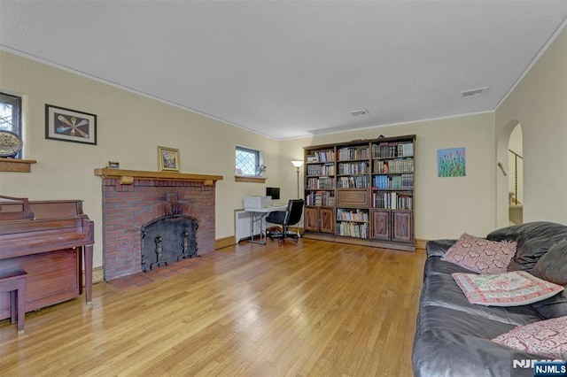 548 Standish Rd, Teaneck, NJ 07666 - living room featuring ornamental molding, wood finished floors, arched walkways, a fireplace, and a desk