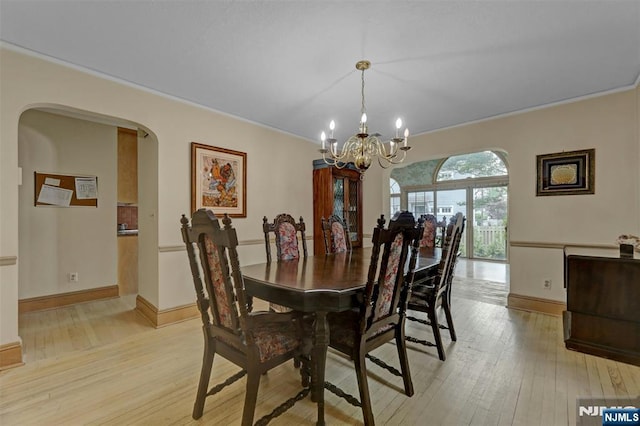 548 Standish Rd, Teaneck, NJ 07666 - dining space featuring a chandelier, light wood-style floors, arched walkways, and crown molding