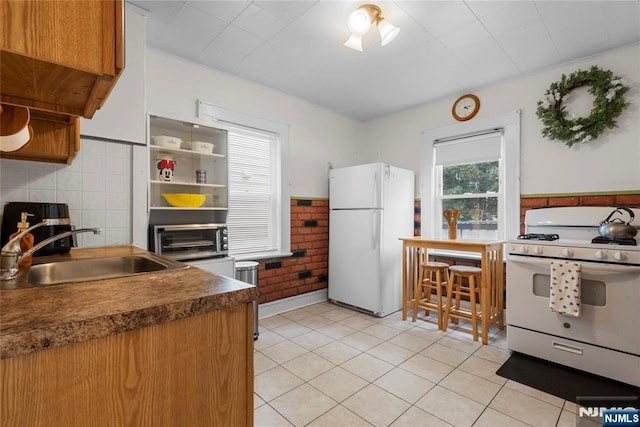 19 Mckinley Ave, West Orange, NJ 07052 - kitchen with white appliances, light tile patterned floors, dark countertops, brick wall, and open shelves