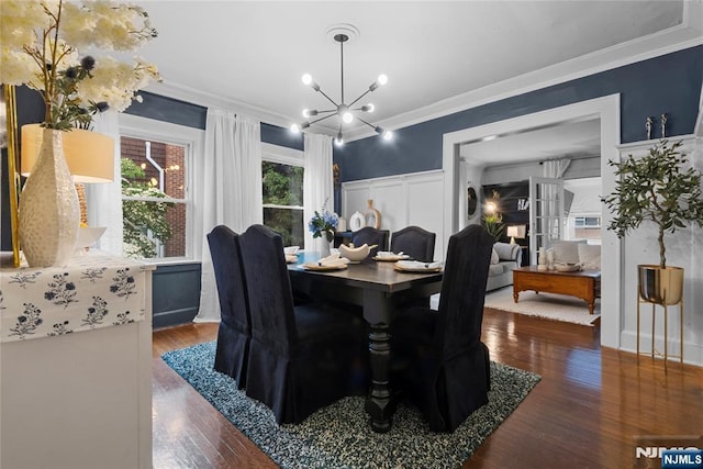 19 Mckinley Ave, West Orange, NJ 07052 - dining space featuring crown molding, a chandelier, wood finished floors, wainscoting, and a decorative wall