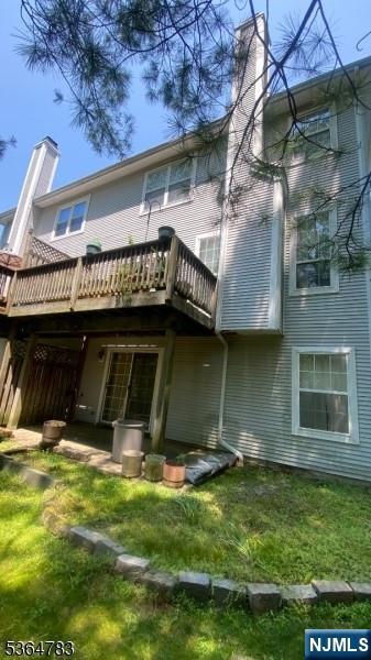 11 Bobolink Ct, Wayne, NJ 07470 - back of house featuring a chimney, a deck, and a lawn