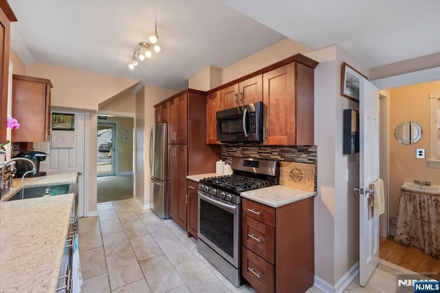 460 River Rd, Bogota, NJ 07603 - kitchen with appliances with stainless steel finishes, tasteful backsplash, brown cabinets, and light stone counters