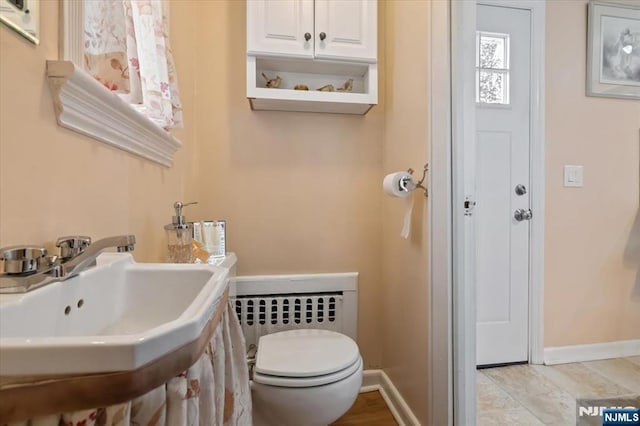 460 River Rd, Bogota, NJ 07603 - half bathroom featuring baseboards and radiator heating unit