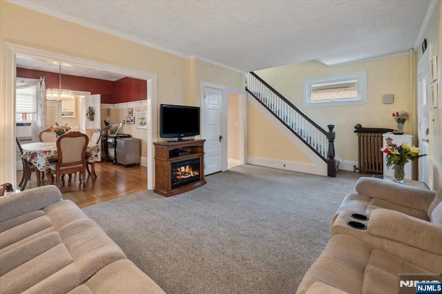 460 River Rd, Bogota, NJ 07603 - carpeted living room with a textured ceiling, radiator, healthy amount of natural light, stairway, and crown molding