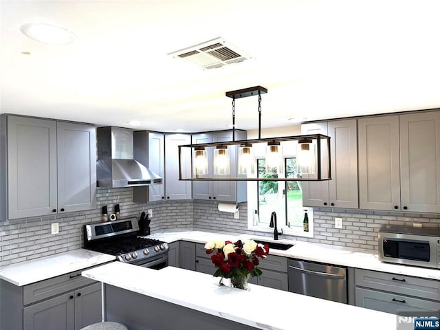 45 Highland Ave, Emerson, NJ 07630 - kitchen featuring gray cabinets, wall chimney range hood, appliances with stainless steel finishes, backsplash, and light stone counters