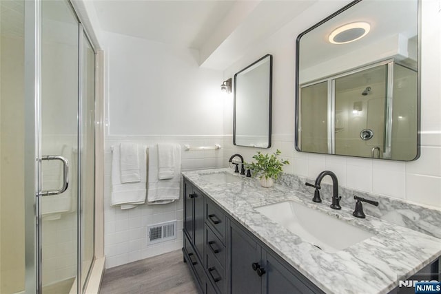 40 Lake Dr, Wayne, NJ 07470 - full bathroom with a shower stall, double vanity, tile walls, and wood finished floors