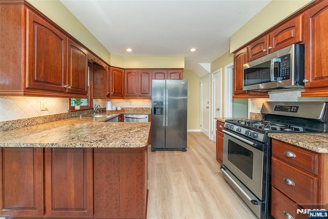 40 Lake Dr, Wayne, NJ 07470 - kitchen featuring stainless steel appliances, light stone counters, a peninsula, light wood-style floors, and decorative backsplash