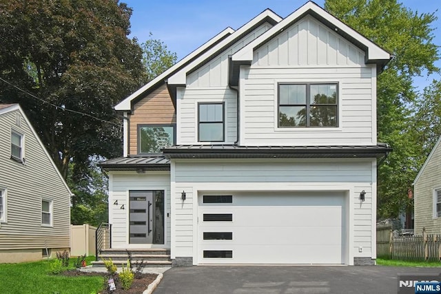 44 N Ashby Ave, Livingston, NJ 07039 - view of front of property with board and batten siding, driveway, a garage, a standing seam roof, and a metal roof