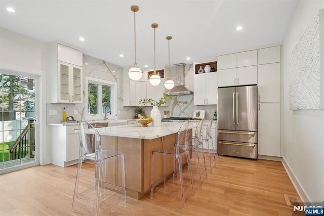 44 N Ashby Ave, Livingston, NJ 07039 - kitchen featuring appliances with stainless steel finishes, range hood, healthy amount of natural light, a kitchen bar, and recessed lighting