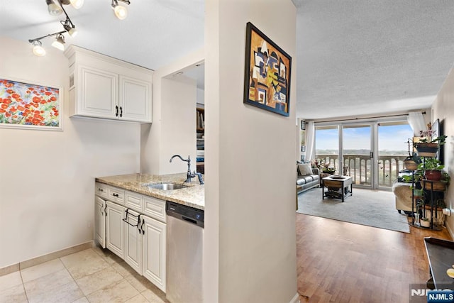 555 N Ave Unit 15W, Fort Lee, NJ 07024 - kitchen with stainless steel dishwasher, light stone countertops, white cabinets, and a textured ceiling