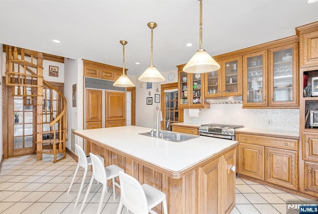 518 Standish Rd, Teaneck, NJ 07666 - kitchen featuring stainless steel gas stove, under cabinet range hood, light tile patterned floors, backsplash, and recessed lighting