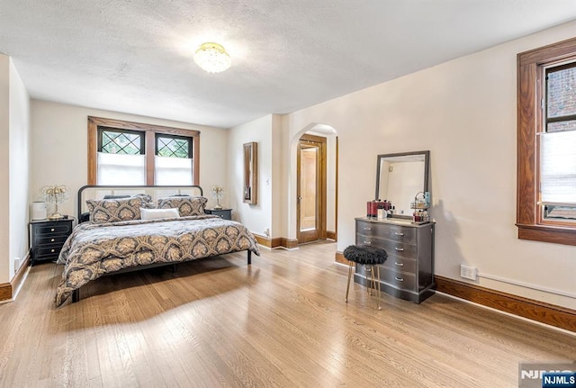 518 Standish Rd, Teaneck, NJ 07666 - bedroom featuring arched walkways, wood finished floors, and a textured ceiling