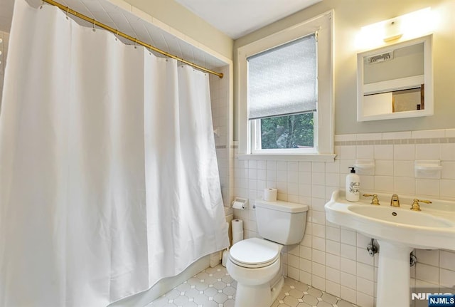 518 Standish Rd, Teaneck, NJ 07666 - bathroom with tile walls, curtained shower, and tile patterned floors